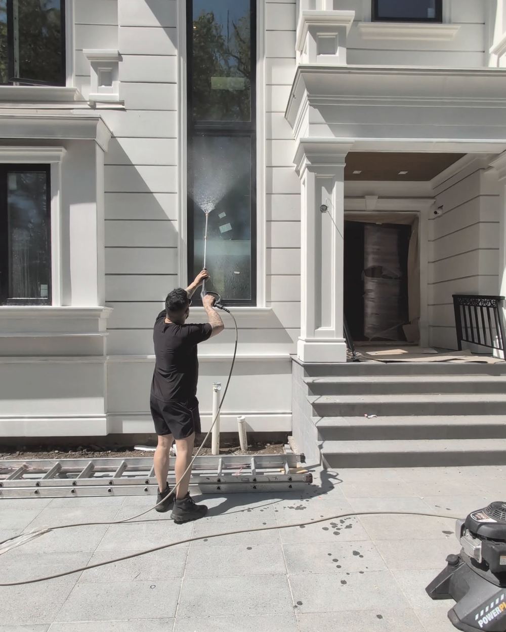 Window cleaning on a white house in West Vancouver